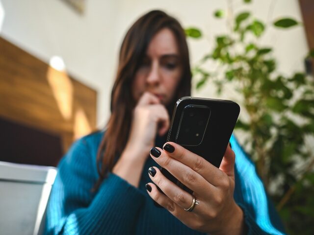a-woman-considers-a-text-message-that-might-be-a-scam-640x480-1 A woman considers a text message that might be a scam