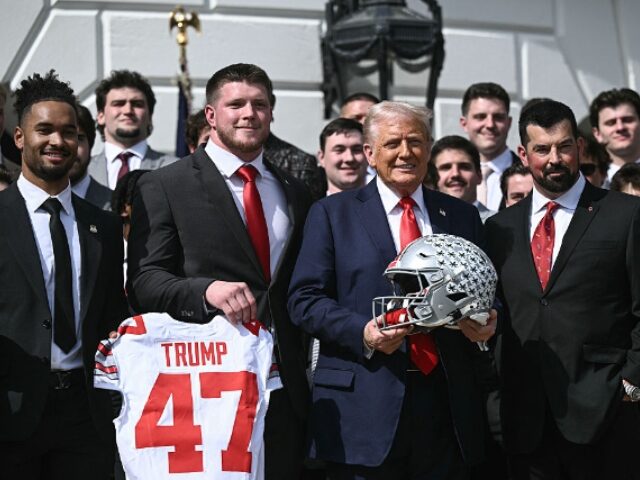 BRENDAN SMIALOWSKI_AFP via Getty Images US President Donald Trump, alongside defensive end Jack Sawyer (2nd L), wide receiever Eme