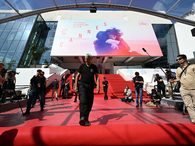 cannes An employee (C) unrolls the red carpet at the Palais des Festivals ahead of the opening ce
