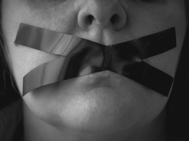 Censorship Portrait of a woman with an x of adhesive tape covering her mouth - stock photo/Getty Imag