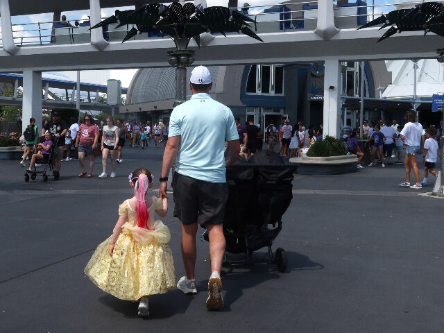 Disneyworld ORLANDO, FL - MAY 31: A man walks with his daughter towards Space Mountain at the Magic Ki