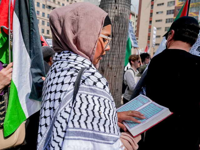 GettyImages-2207735574 A Muslim woman reads the Quran as pro-Palestine protesters demonstrate against the arrest