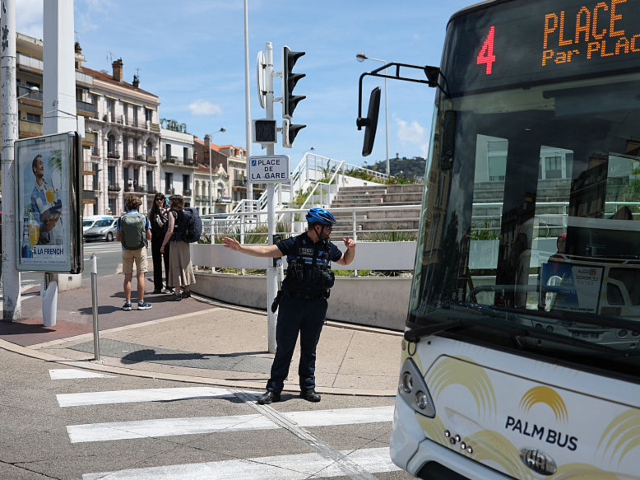GettyImages-2216053254 A municipal police officer directs traffic as traffic lights no longer function after a po