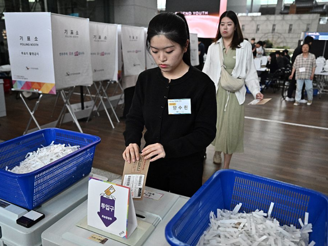 GettyImages-2216938662 A woman votes at a polling station installed in the departures area of the Incheon Interna