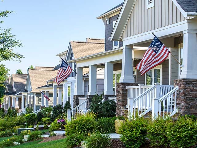 gettyimages-541823470-640x480-1 American Flags hang from the front porch of a row of upscale Victorian-style homes in cele