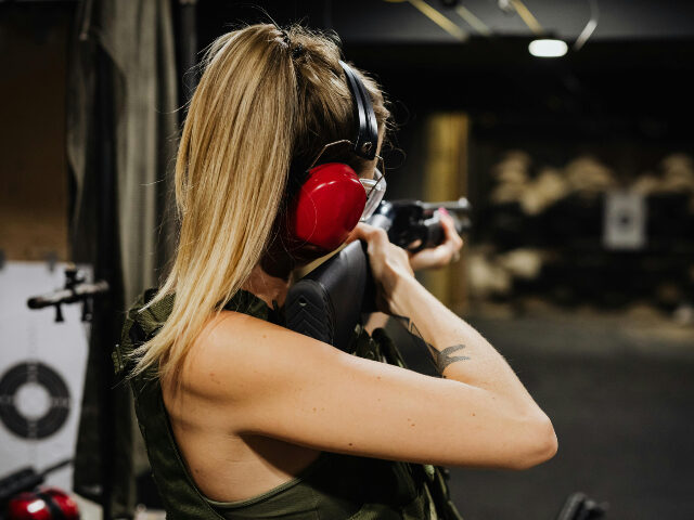pexels-karolina-grabowska-5202391 woman in tank top holding black rifle