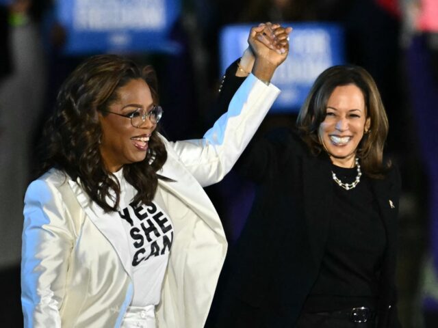 the team US producer and actress Oprah Winfrey (L) holds up US Vice President and Democratic presid