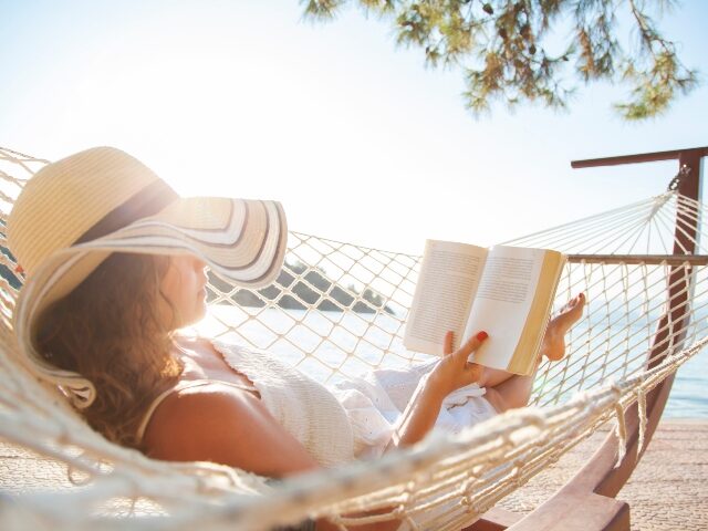 woman-enjoying-a-summer-novel-640x480-1 Woman in a hammock with book on summer day