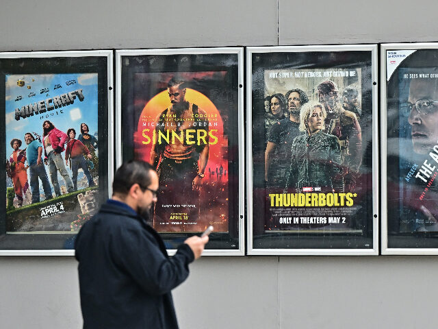 A man walks past movie posters at at AMC Theater … A man walks past movie posters at at AMC Theater in Montebello, California on May 5, 2025.