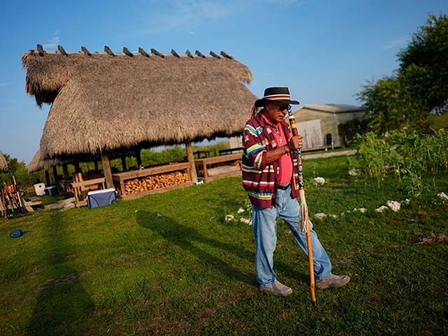 ap24355469987719-1-640x480-1 Miccosukee Tribal elder Michael Frank walks past chickees, stilt homes, used for community