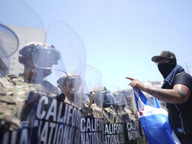 California National Guard (Eric Thayer / Associated Press) Un manifestante se enfrenta contra una fila de agentes de la Guardia Nacional de Estados U