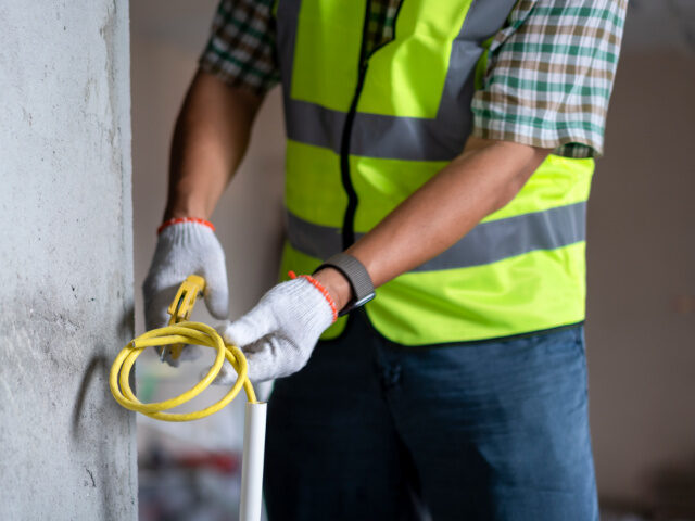 Cutting the Cord. Sammyvision_Getty Close-up of construction worker cutting wires - stock photo