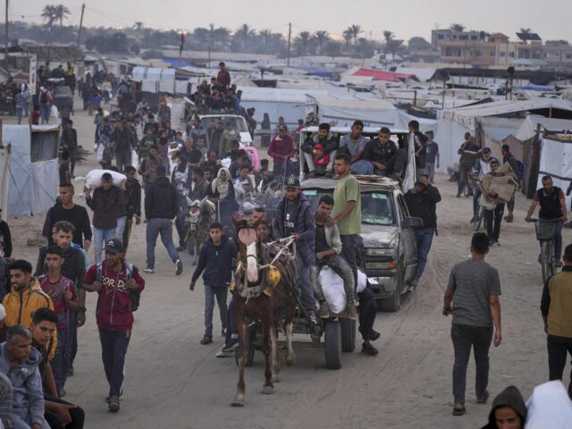 Palestinians carry bags filled with food and humanitarian aid provided by the Gaza Humanit