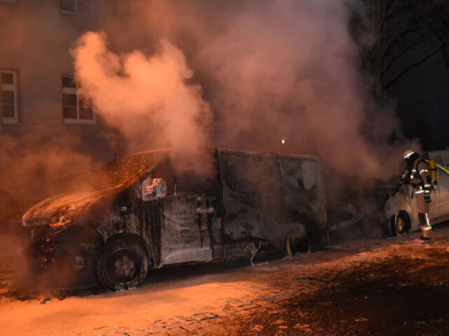 Vehicles burn in Berlin 01 February 2019, Berlin: Smoke rises from delivery vehicles on which logos of the online