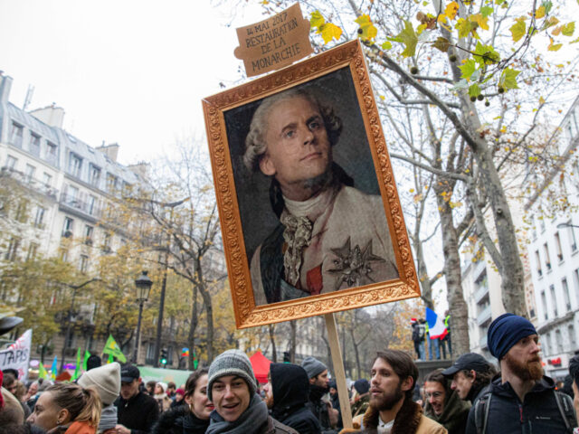 gettyimages-1186738262-2-640x480-1 A protester holds a caricature painting depicting France's President Emmanuel Macron as a