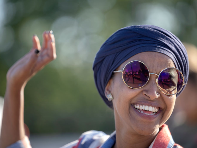 GettyImages-1413918923 U.S. Rep. Ilhan Omar waves to passerbys for support during a voter engagement event on the