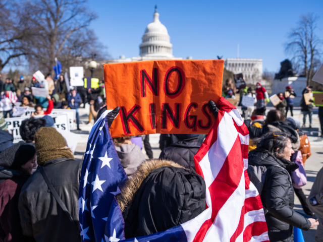 GettyImages-2199615140 UNITED STATES - FEBRUARY 17: Demonstrators hold signs during the No Kings Day protest to o
