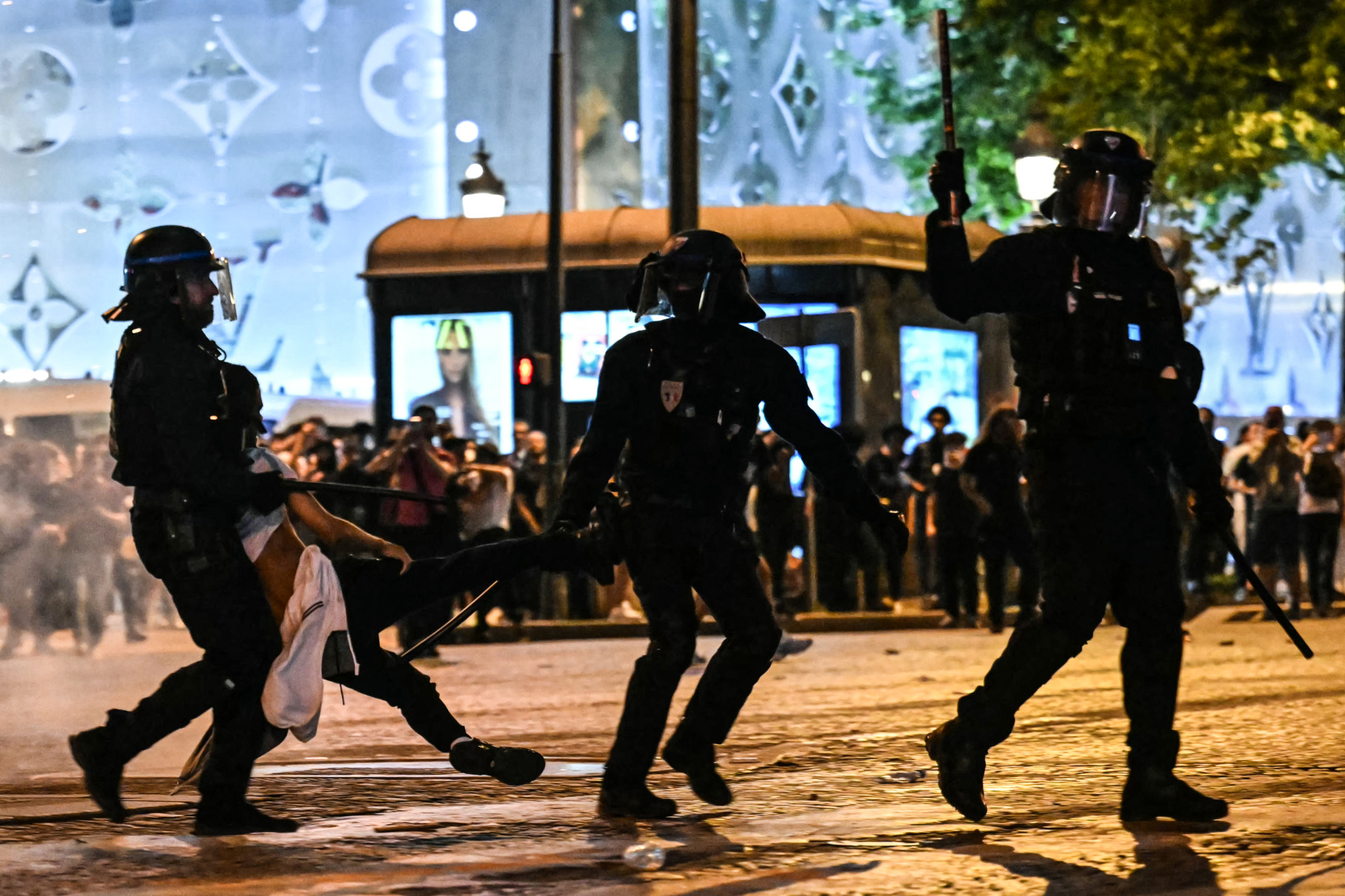 gettyimages-2217311058 TOPSHOT - Anti-riot police officers detain a person as Paris Saint-Germain supporters celebrate after PSG won the UEFA Champions League final football match between Paris Saint-Germain (PSG) and Inter Milan held in Munich, on the Champs-Elysees avenue in Paris on May 31, 2025. (Photo by LOU BENOIST / AFP) (Photo by LOU BENOIST/AFP via Getty Images)