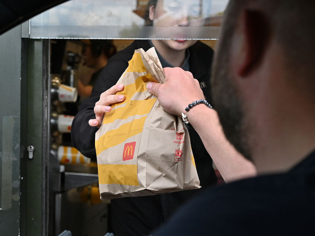 GettyImages-2217320728 BASILDON, ENGLAND - MAY 25: A driver collects a McDonald's order at a drive-through restau