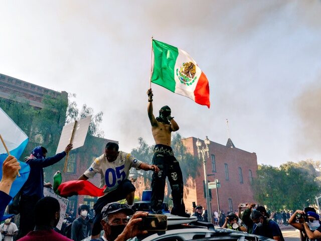 Trump Deploys National Guard To LA Over Newsom's Objections Protesters stand on top of a destroyed vehicle in Los Angeles, California, US, on Sunday,