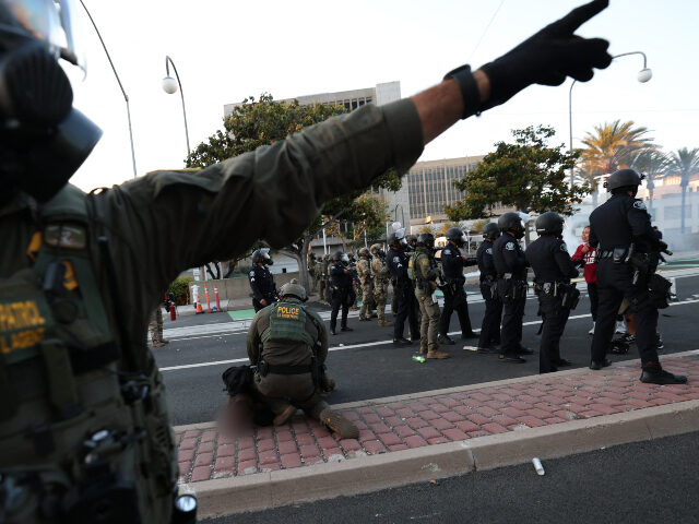 GettyImages-2218861575 (1) A US Border Patrol agent gestures near another arresting a protester near the United State
