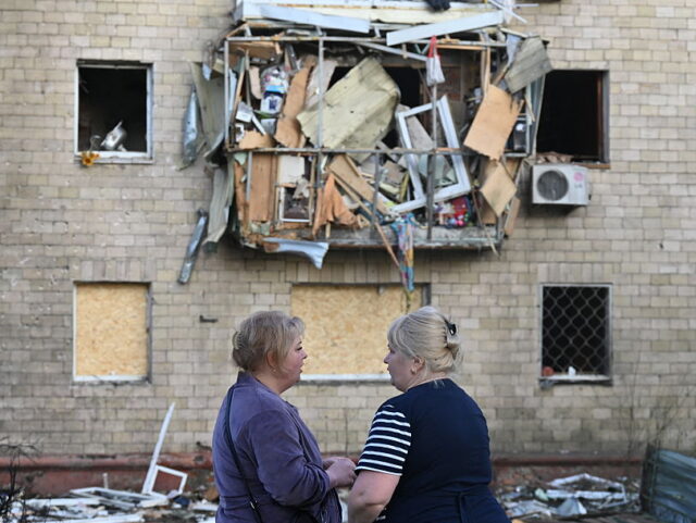 TOPSHOT-UKRAINE-RUSSIA-CONFLICT-WAR TOPSHOT - Women stand near a damaged residential building following a Russian drone strike