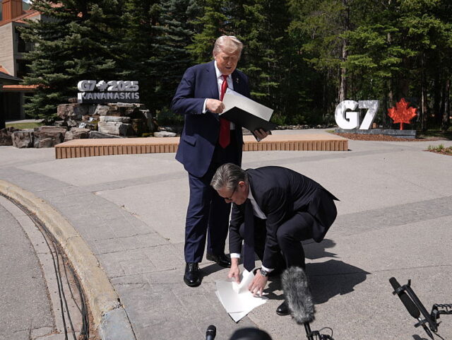 TOPSHOT-CANADA-G7-SUMMIT-DIPLOMACY TOPSHOT - British Prime Minister Keir Starmer picks up US-UK trade deal papers dropped by