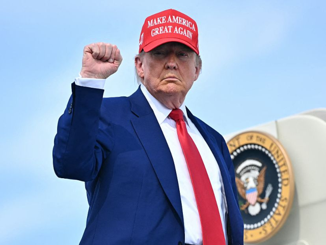 GettyImages-2220598276 TOPSHOT - US President Donald Trump pumps his fist as he boards Air Force One at Morristow
