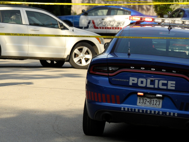 GettyImages-823927070 Arlington PD walking past the white Dodge sedan that a suspect car-jacked and abandoned ne