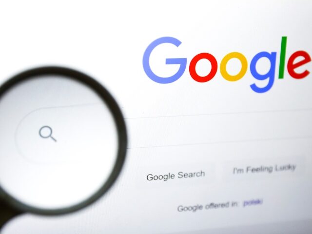 Google magnifying glass A magnifying glass is photographed with Google logo displayed on a laptop screen for illus
