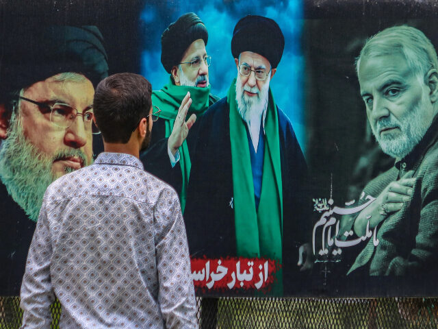 Hezbollah_Iran A man looks at a billboard featuring the portraits of (Left to Right) Hassan Nasrallah, th