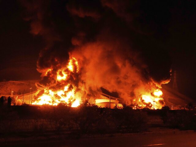 Iran explosion (Vahid Salemi / Associated Press) Flames rise from an oil storage facility after it appeared to have been hit by an Israeli