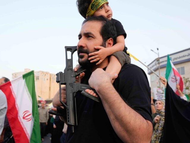 Iran parade 5 (Vahid Salemi / Associated Press) An Iranian protester holds his son with a toy gun in an anti-U.S. and anti-Israeli rally a