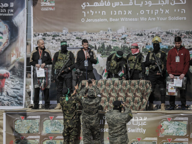 Islamic Jihadis Hamas and Islamic Jihad militants stand next to Russian-Israeli hostage Sasha Alexander Tr