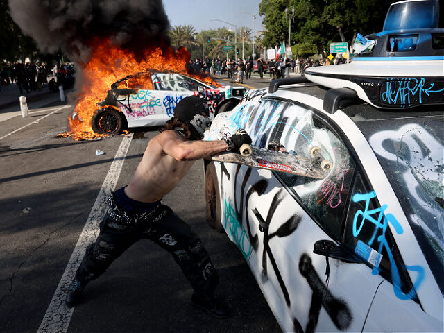 June8-25-protester-damages-vehicle-Los-Angeles-getty Los Angeles, CA. June 8, 2025 A protester damages a Waymo vehicle at Los Angeles St. and A