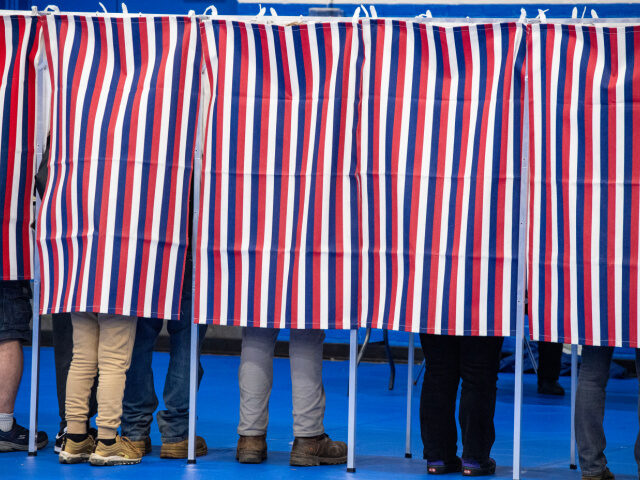 Legs of Voters in Booths People fill out their ballots in voting booths at the Green Street Community Center in Con