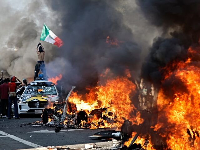 mexican flag riots LOS ANGELES, LOS ANGELES - JUNE 08: A protestor holds up a Mexican flag as burning cars li