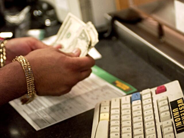 money transfer Sales Associate Johnny DeLaCruz counts money at a Western Union location in New York on Fe