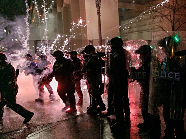 police fireworks PORTLAND, OREGON, USA - DECEMBER 31: Protesters throw fireworks to police officers during