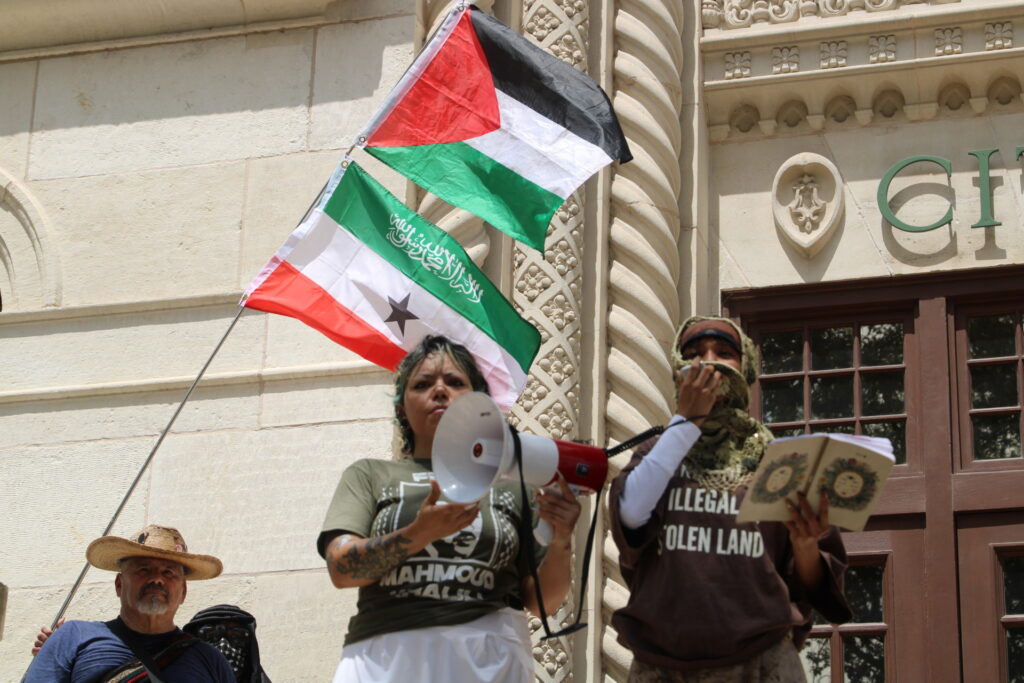 protesters-read-anti-israel-anti-ice-messages-next-to-palestinian-flag-at-anti-ice-protest-photo-by-randy-clark-1024x683-1 Protesters read anti-Israel, anti-ICE messages next to Palestinian flag at anti-ICE protest photo by Randy Clark (Randy Clark/Breitbart Texas)