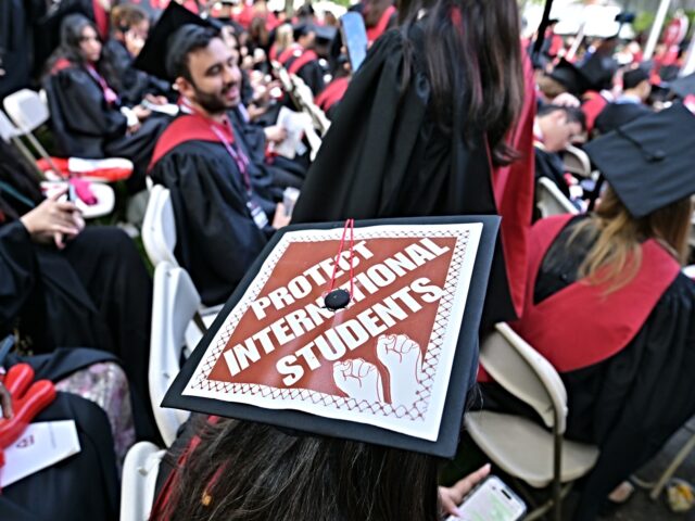 student migrants CAMBRIDGE, MA - MAY 29: A Harvard University graduate with a message in support of interna
