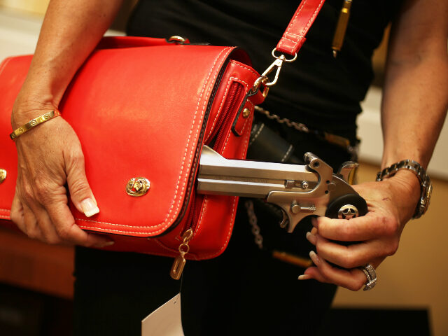 Susan Kushlin poses with a concealed-carry handbag that her company, Gun Girls, Inc., crea