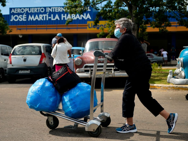 GettyImages-1229773940 A Cuban-American carries luggage as she leaves Havana's Jose Marti International Airport o