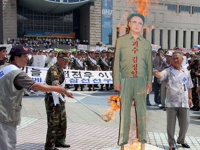 gettyimages-1541112049 Veteran South Korean soldiers set alight an effigy (C) of North Korean leader Kim Jong-Il, 04 July 2002, during a demonstration in front of the Seoul War Museum. Some 3,000 veterans gathered to protest against North Korea and South Korean President Kim Dae-Jung's "Sunshine Policy" of reconciliation towards the North, following the death of four South Korean soldiers in a clash at sea last week. AFP PHOTO/CHOI JAE-KU (Photo by CHOI JAE-KU / AFP)