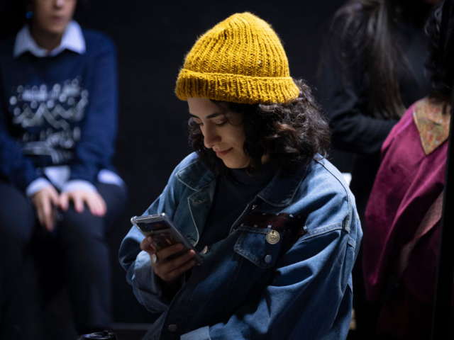 GettyImages-2197454124 A young Iranian woman uses her smartphone during the Da-Concept Store Fashion and Design e