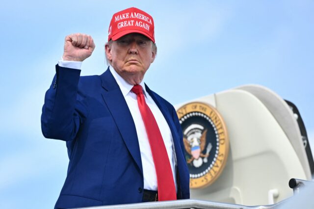 TOPSHOT - US President Donald Trump pumps his fist as he boards Air Force One at Morristow