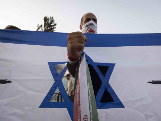 Iran parade Star of David 3 (Morteza Nikoubazl/NurPhoto via Getty) An Iranian man wearing his country's flag stands behind an anti-Israeli banner during