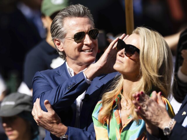 Newsom shades (Derrick Tuskan / Associated Press) California Governor Gavin Newsom, left, waves to the crowd while attending the opening cer