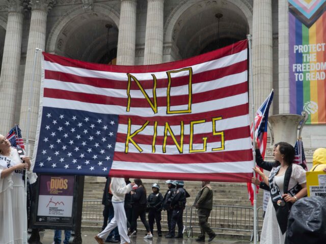 Prior to a huge protest march, two women, wearing long, flowing dresses and sashes, hold a